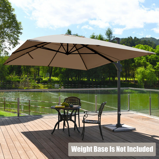 A rectangular cantilever umbrella in a coffee color opened and placed over a patio table and chairs, with a body of water and trees in the background. The image caption states that the weight base is not included.