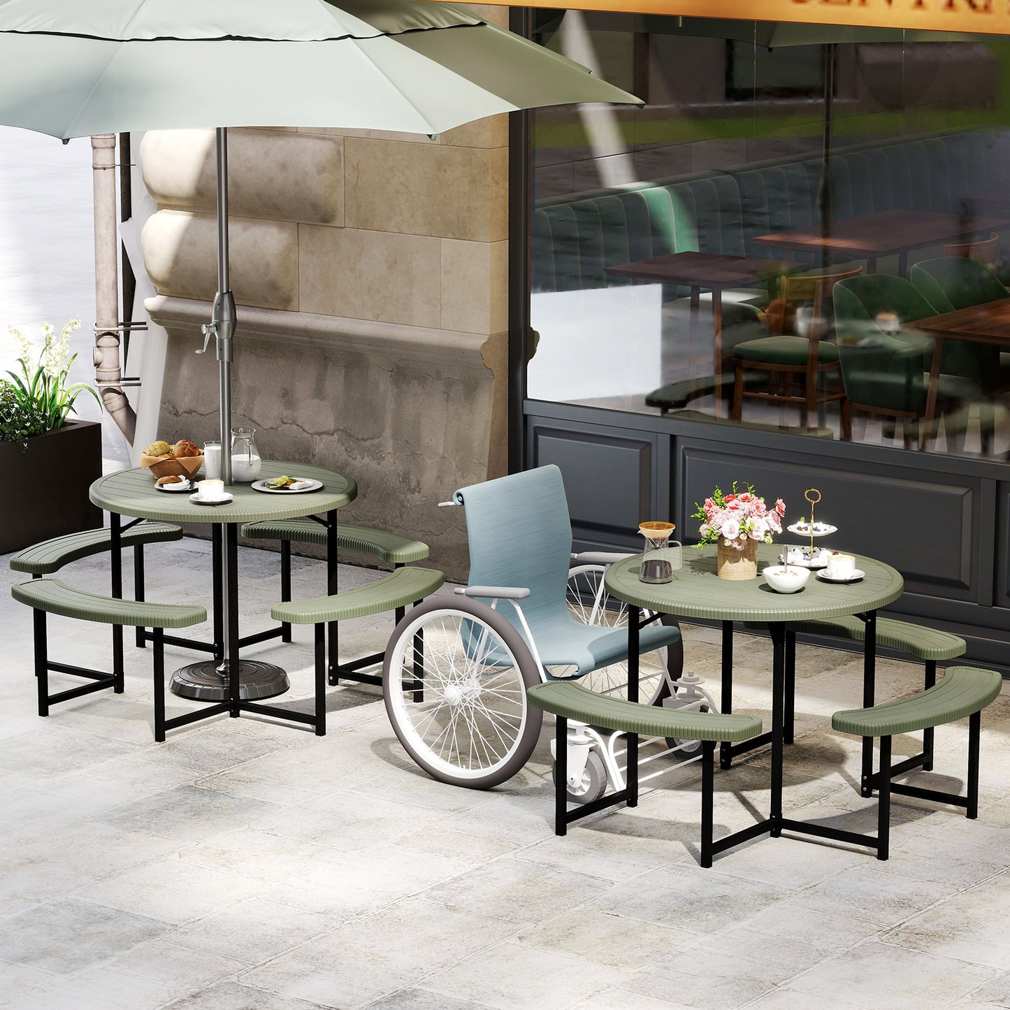 A round picnic table with a HDPE tabletop and black metal legs, accompanied by four  curved benches with a faux shell texture. The set is placed on a wooden deck with outdoor seating and a small umbrella in the background.