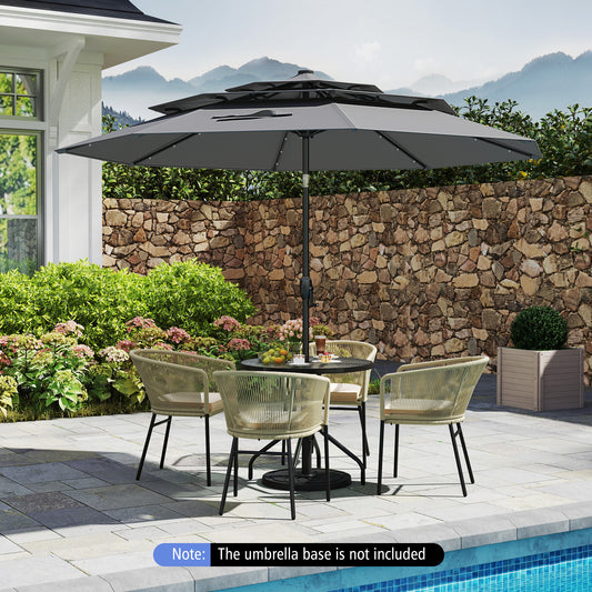 A gray 10 feet solar patio umbrella with 32 LED lights, featuring a 3-tier vented top, placed over a table and chairs set in an outdoor setting with a stone wall and pool in the background. Note: The umbrella base is not included.