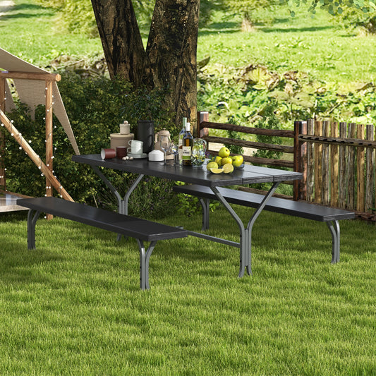 A black picnic table and bench set on a grassy outdoor area with a tablecloth, glasses, and a water bottle placed on the table.