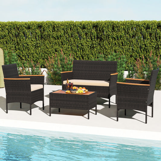 A 4 piece patio wicker sofa set with two rattan chairs and a loveseat with a table placed by a poolside, with a hedge in the background.