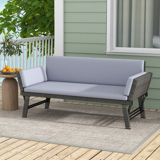 An outdoor convertible sofa daybed with adjustable armrests, gray cushions, and a metal frame, placed on a wooden deck with a garden in the background.