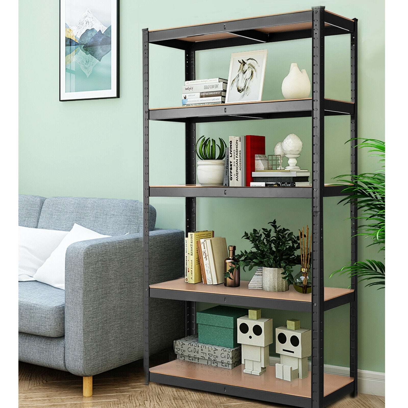 A 5-level garage tool shelf storage unit with black metal frames and brown wooden shelves, placed in a room next to a grey sofa with various home decor items on the shelves.