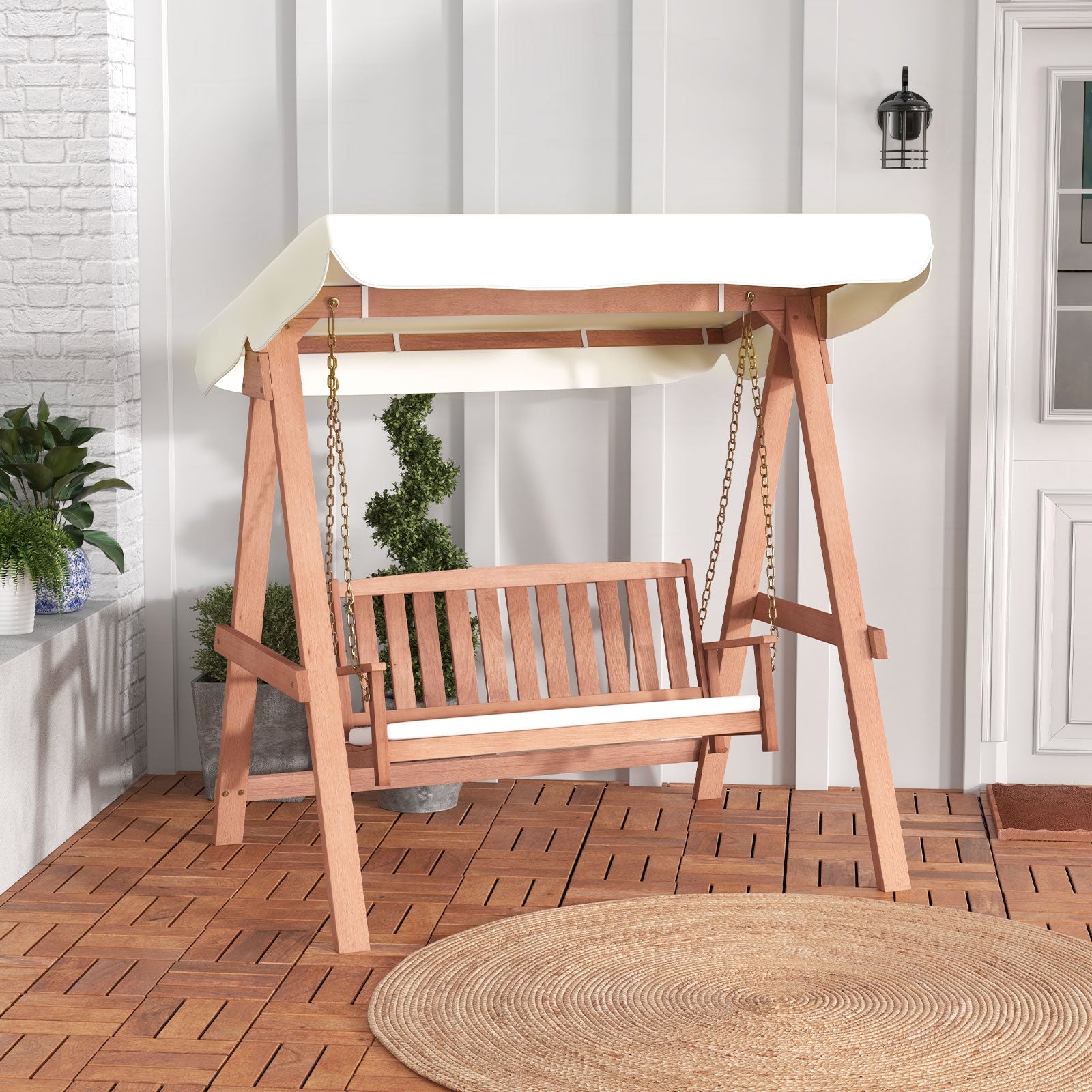 An outdoor 2-seat swing bench with a wooden frame, metal hanging chains, and a white canvas canopy, set on a patio.