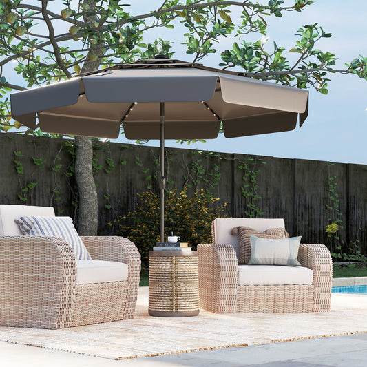 A 10 feet solar patio umbrella with a 3-tier vented top in gray, beige, and navy colors, featuring an auto tilt design, solar-powered LED lights, and a crank handle, surrounded by outdoor furniture on a patio.